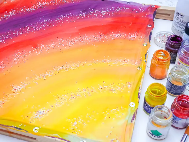 Tęczowy gradient na jedwabiu posypany solą, obok słoiczki barwników